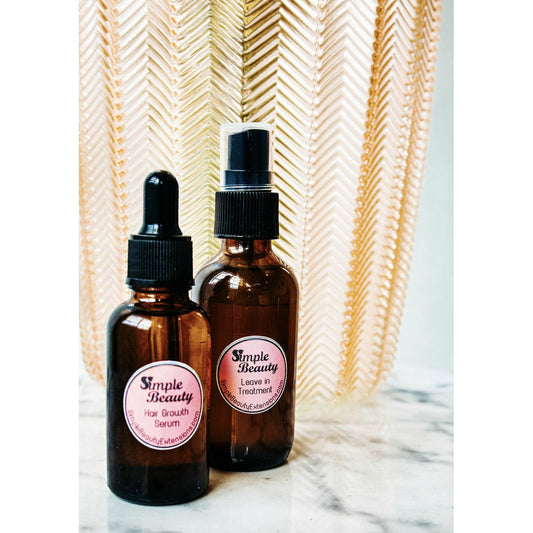 Amber glass bottles of Simple Beauty Replenished leave-in scalp treatment and hair growth serum on marble surface with decorative background